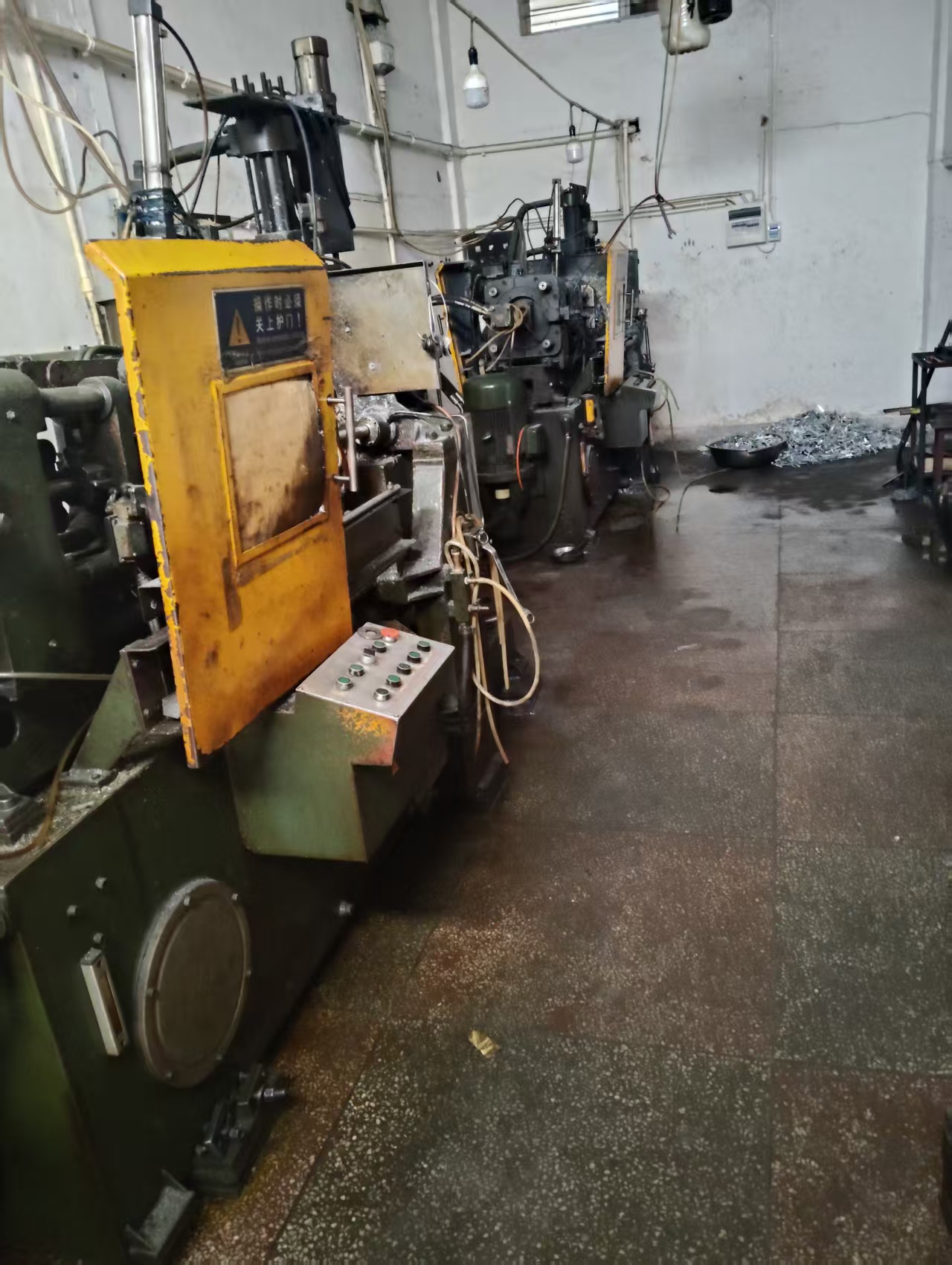 Zinc-alloy die-casting machine with yellow safety guarding on the workshop floor