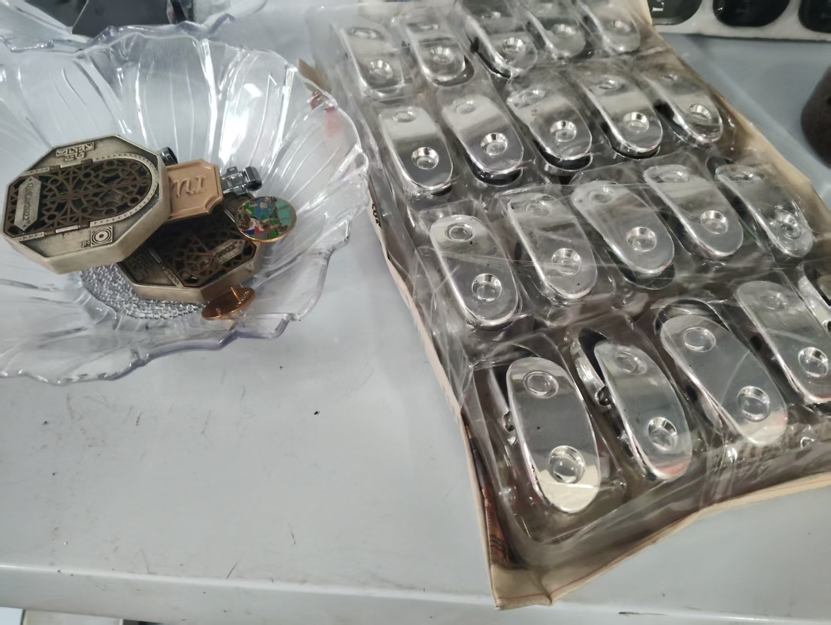 Finished zinc-alloy hardware components including badges and clips packed and ready for shipment