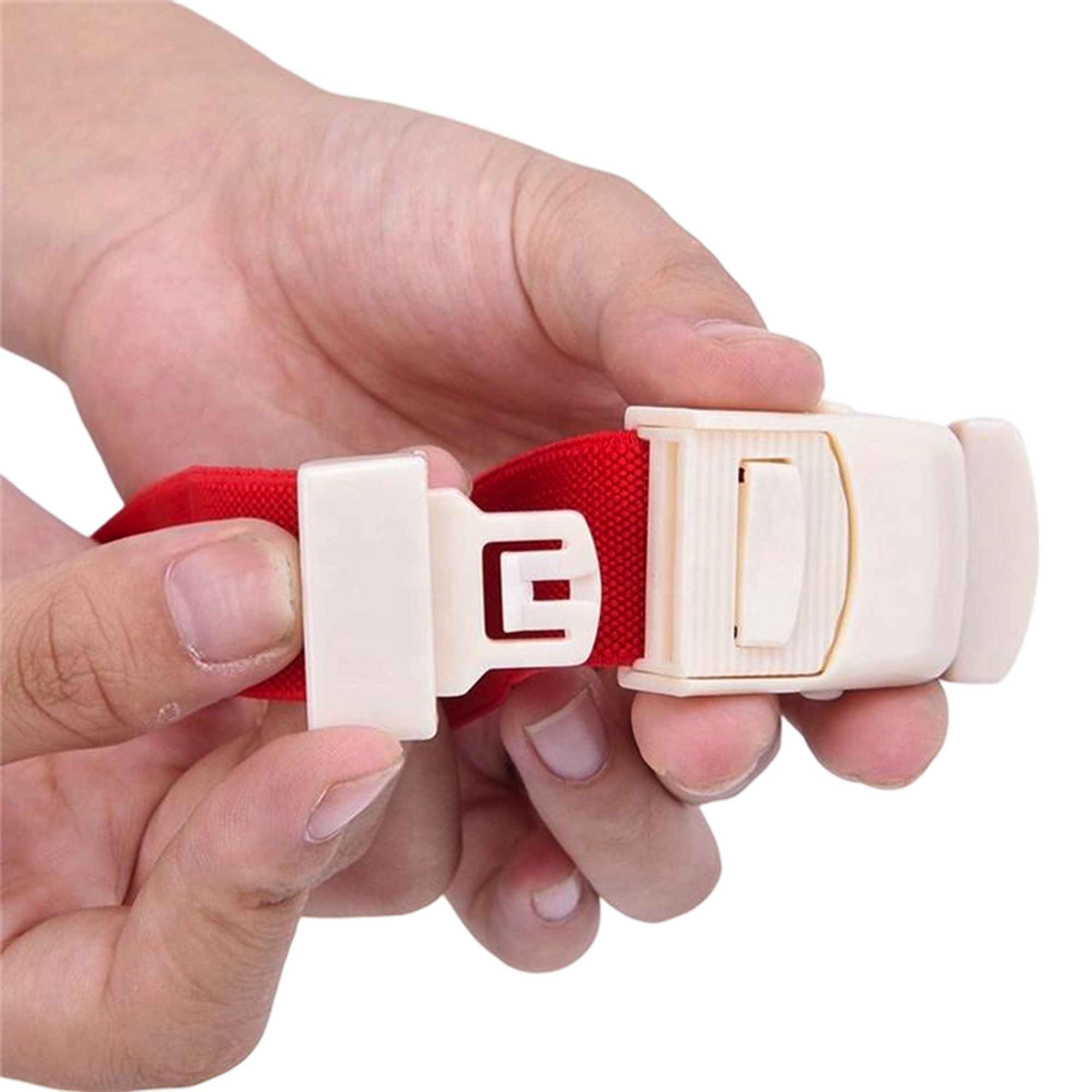 Hand holding the white quick-release buckle on a red tourniquet strap