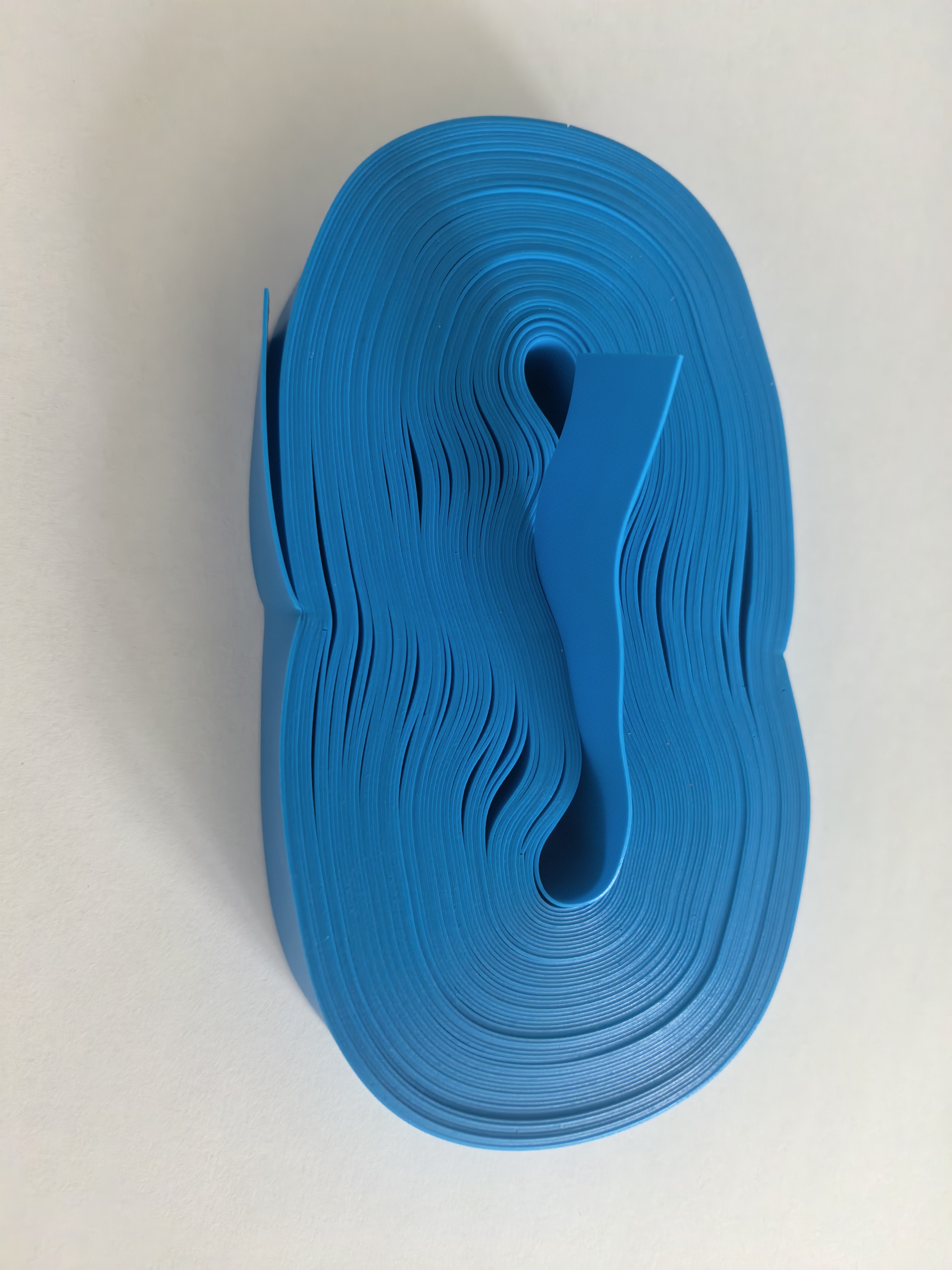Folded blue disposable tourniquet strip batch on an inspection surface