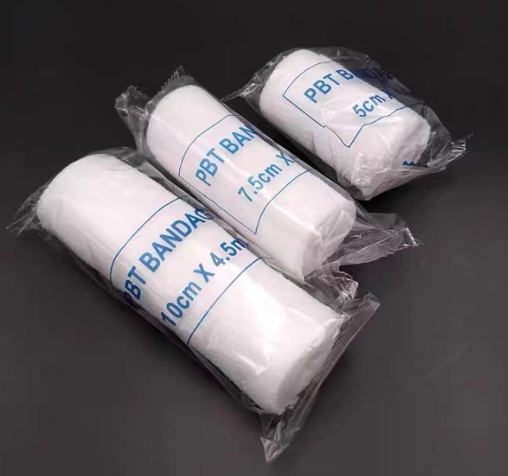 Three packaged PBT bandage rolls grouped on a dark surface