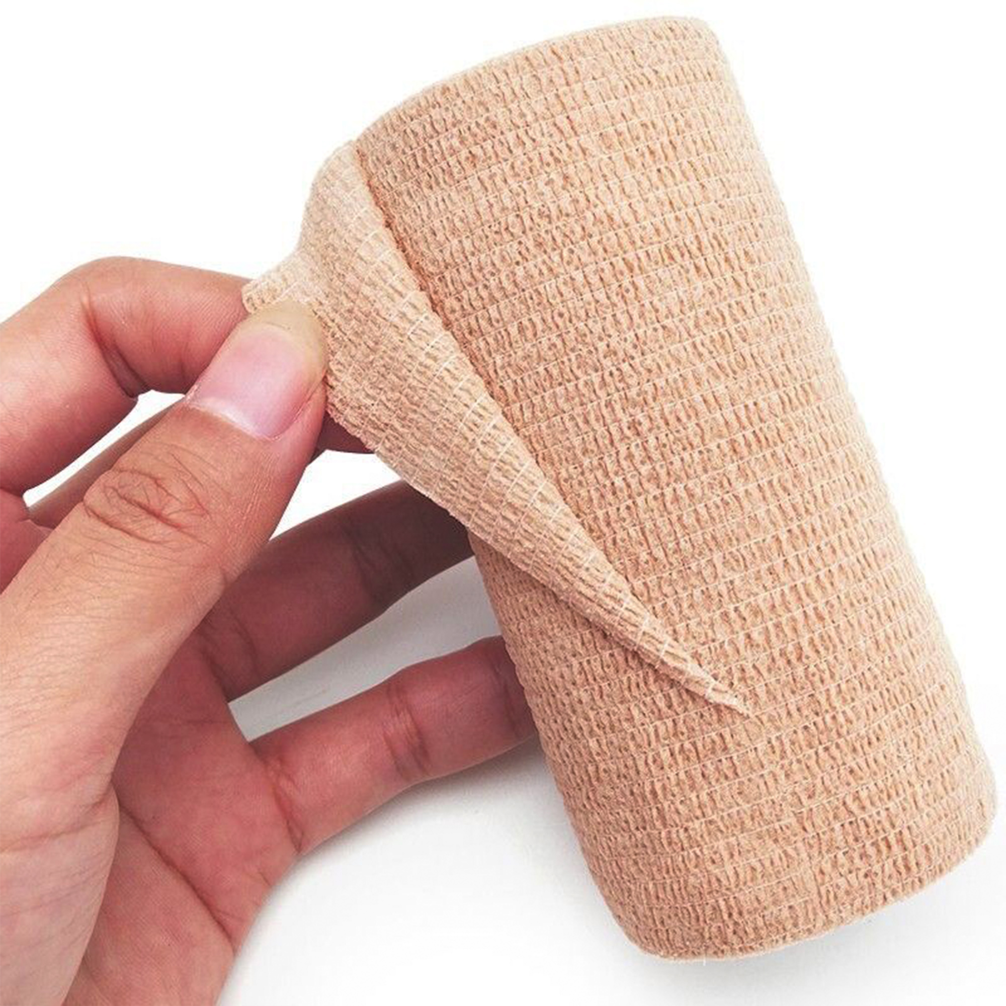 Hand unrolling a beige self-adhesive bandage to show its texture