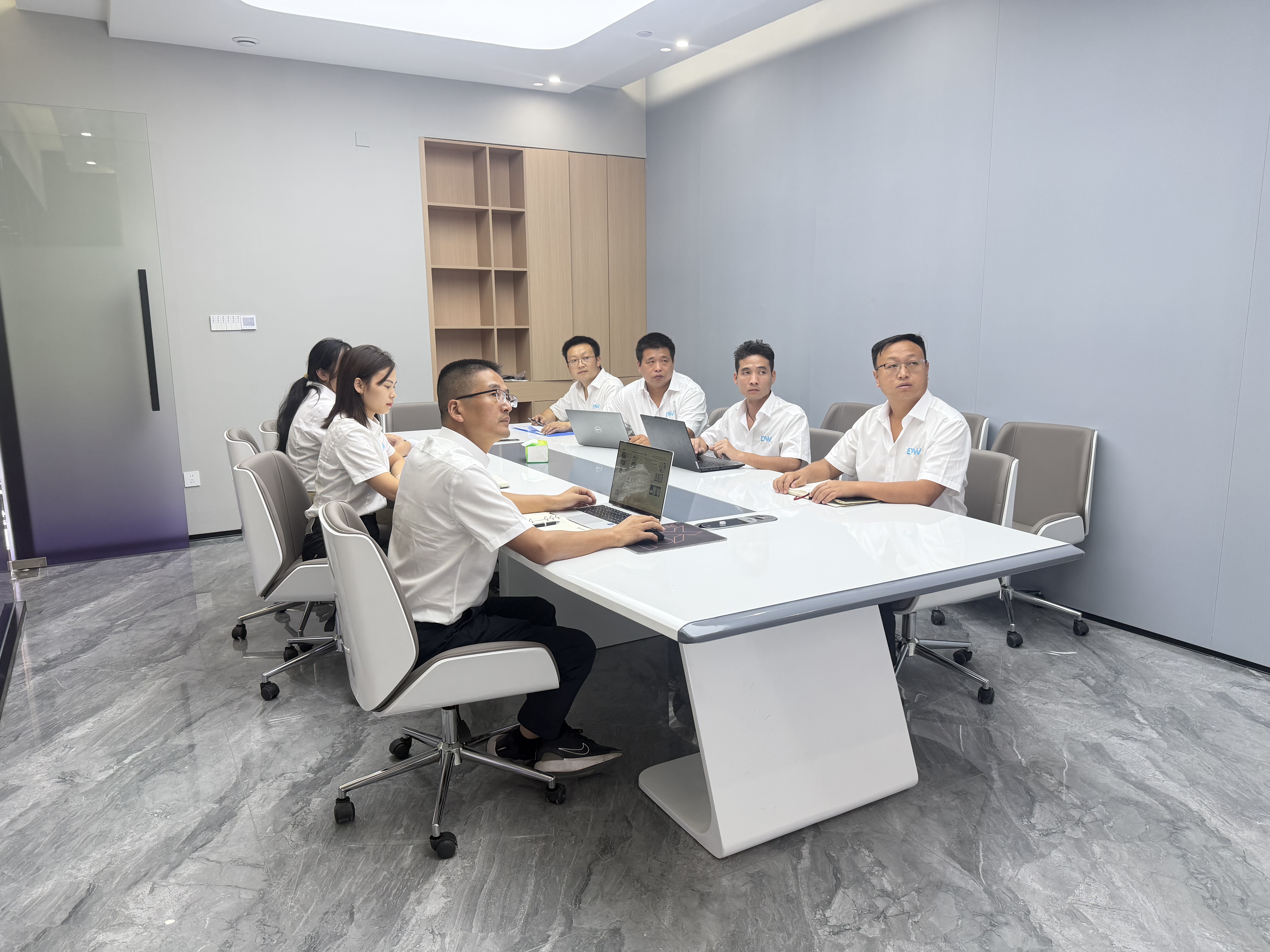 Dawei staff discussing a project around a meeting table.