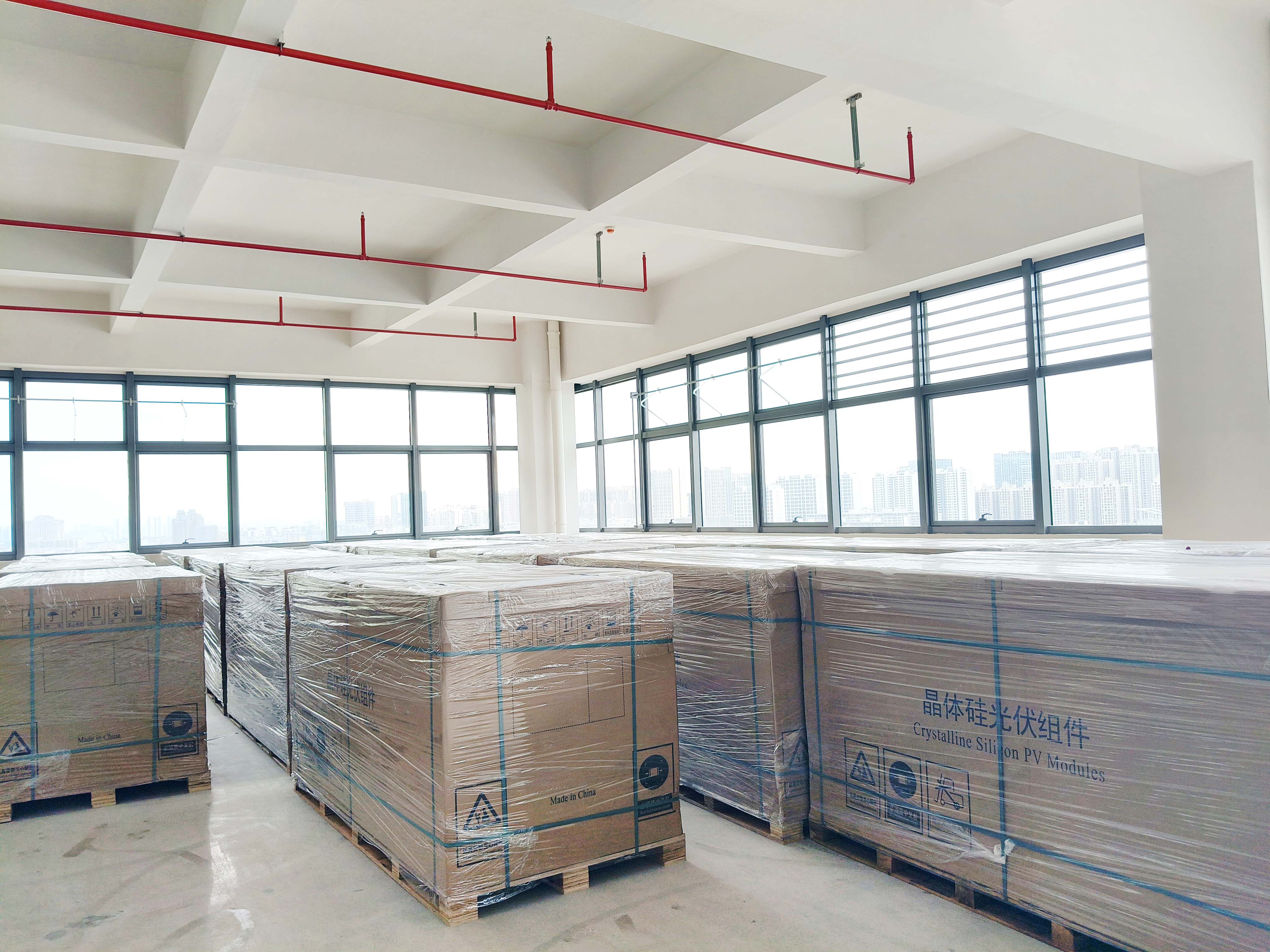 Packed equipment and crates beside the windows of a warehouse area.