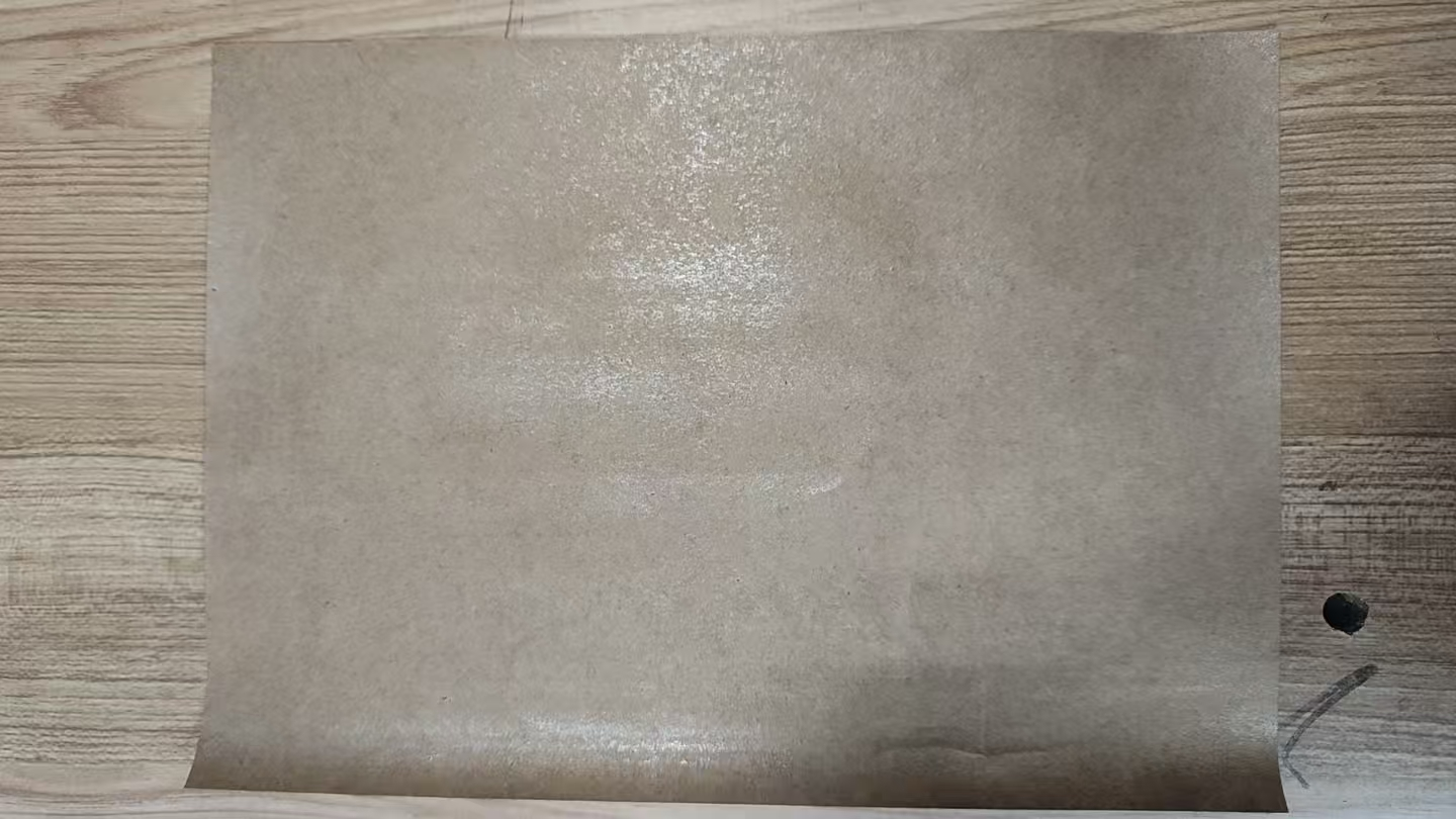 Laminated paper sample sheet laid flat on a wooden surface