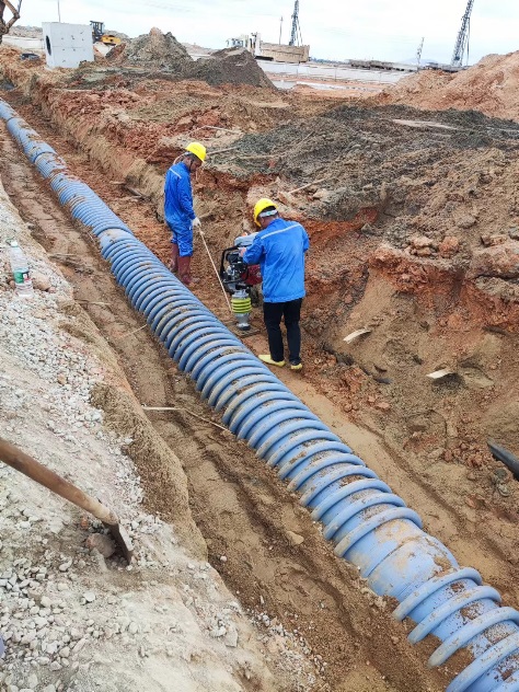 Pipe sections laid along a trench for installation.