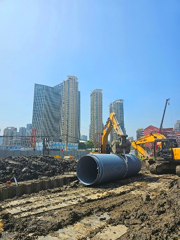 Excavation equipment and pipe sections on site.