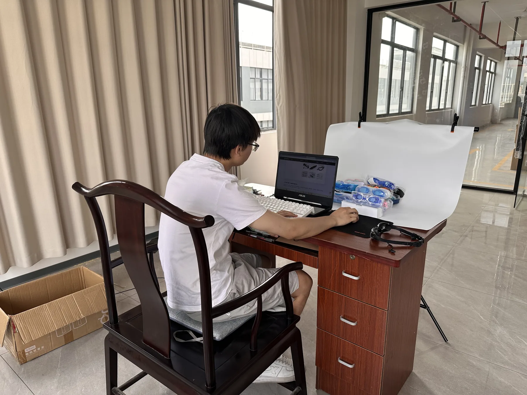 Worker photographing swim products at a desk