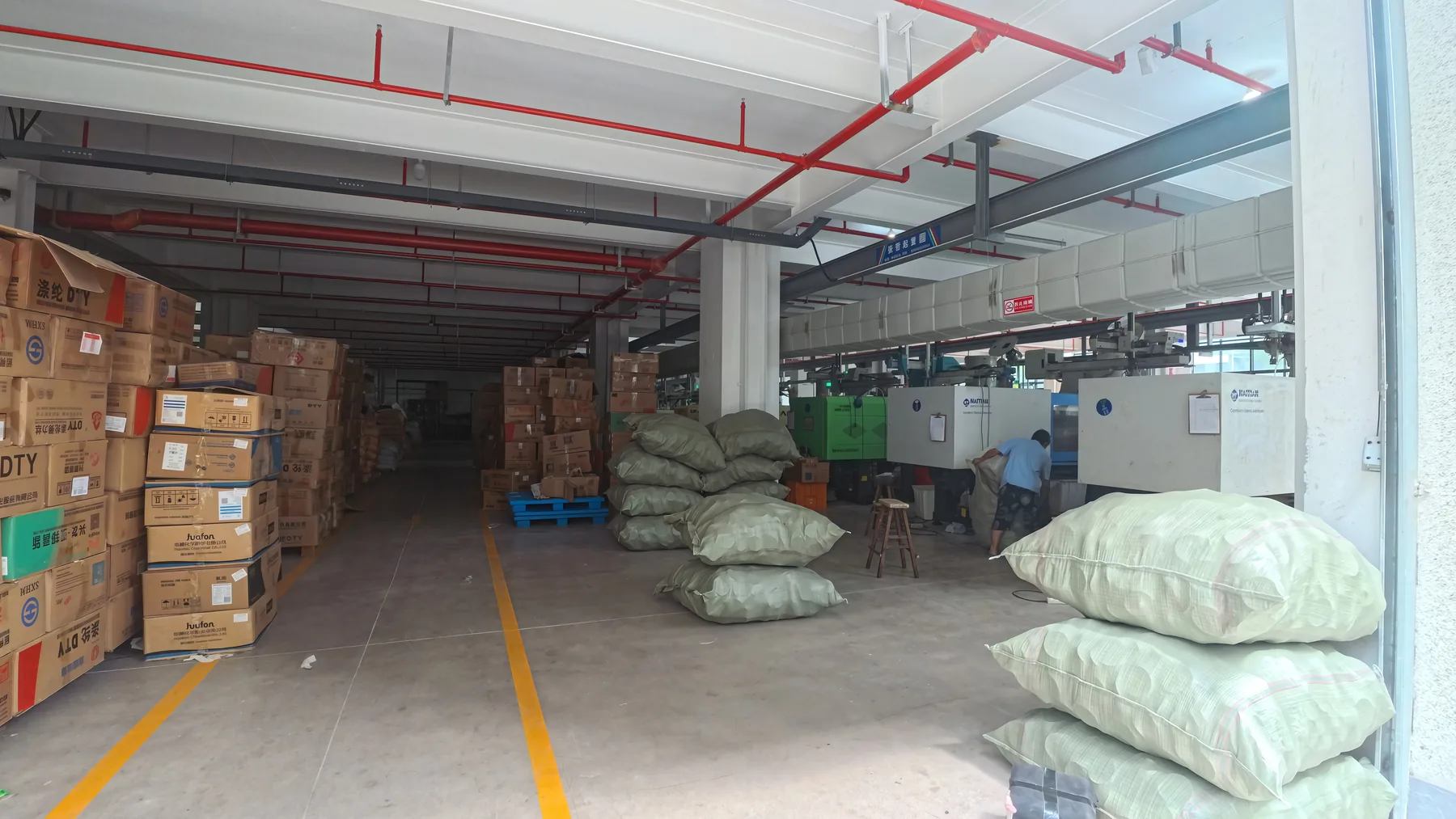 Wide workshop aisle with machines and bagged materials