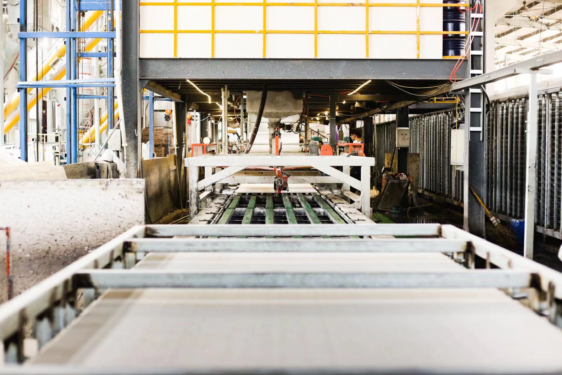 Board forming line with white panels moving along the equipment