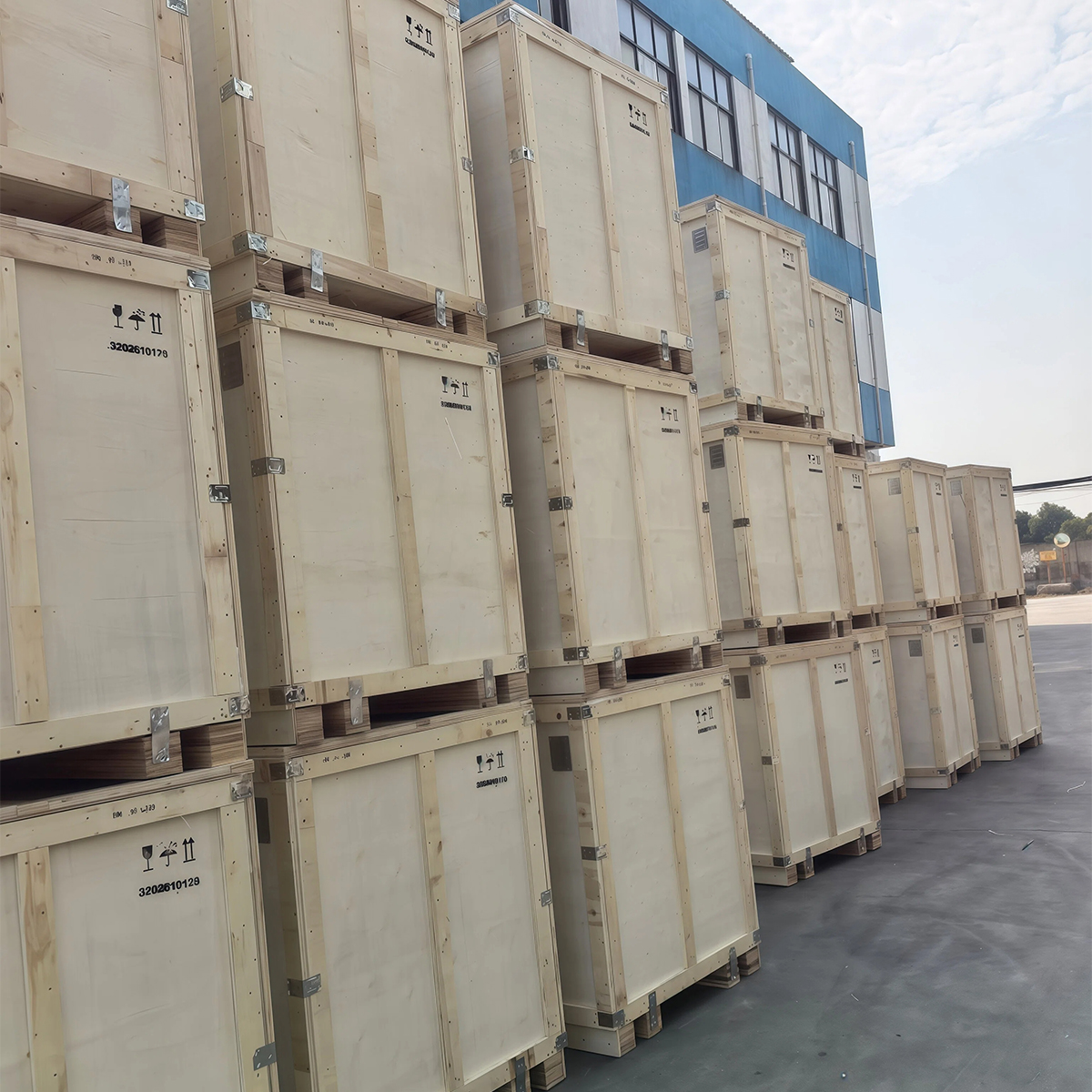 Cream-finished plywood crates stacked outdoors before shipment