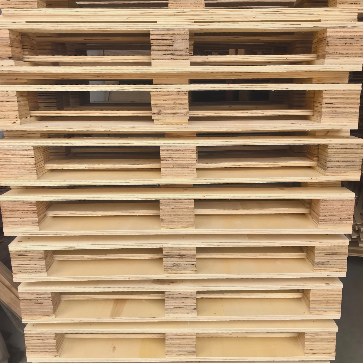 Light-toned plywood pallets stacked in a warehouse