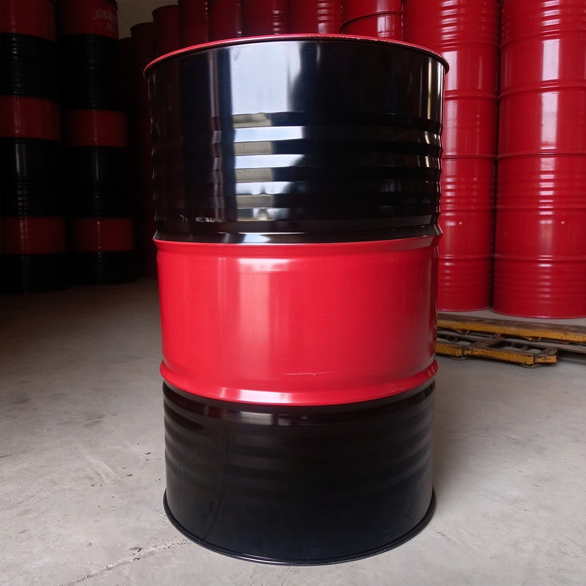 A single unbranded red and black steel drum, shown as generic packaging context.